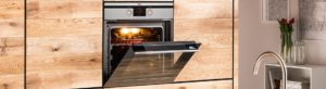 A kitchen set displaying an oven with the door angled open